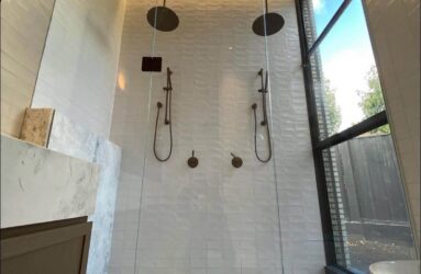 A floor to ceiling in-line shower with matte black detailing